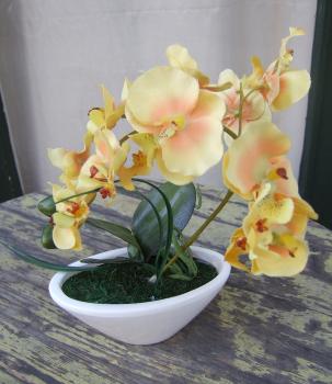 Künstliche Orchidee gelb im ovalen Gefäß